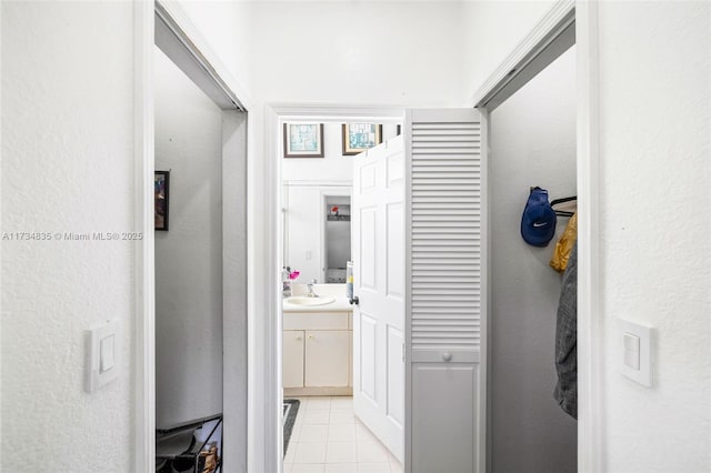 hallway with sink and light tile patterned floors