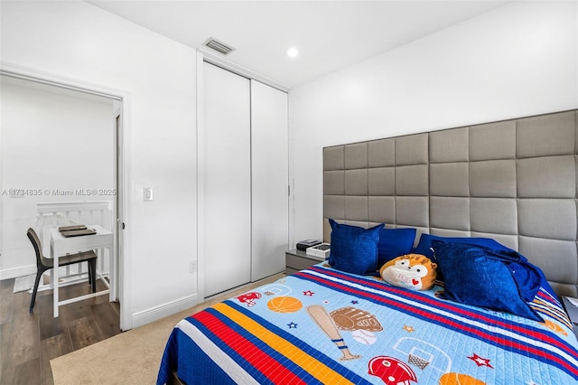 bedroom featuring dark hardwood / wood-style floors and a closet