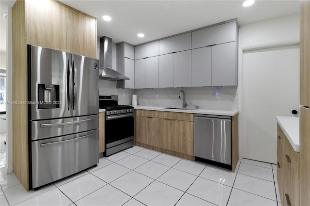 kitchen featuring sink, light tile patterned floors, appliances with stainless steel finishes, wall chimney range hood, and backsplash