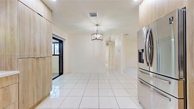 kitchen with pendant lighting, light brown cabinetry, stainless steel fridge, and light tile patterned flooring