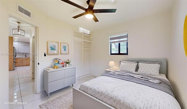 unfurnished bedroom featuring light tile patterned floors, a closet, and ceiling fan