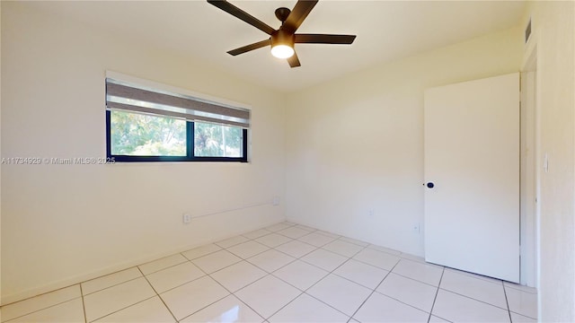 tiled empty room featuring ceiling fan