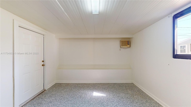 basement featuring an AC wall unit and wood ceiling