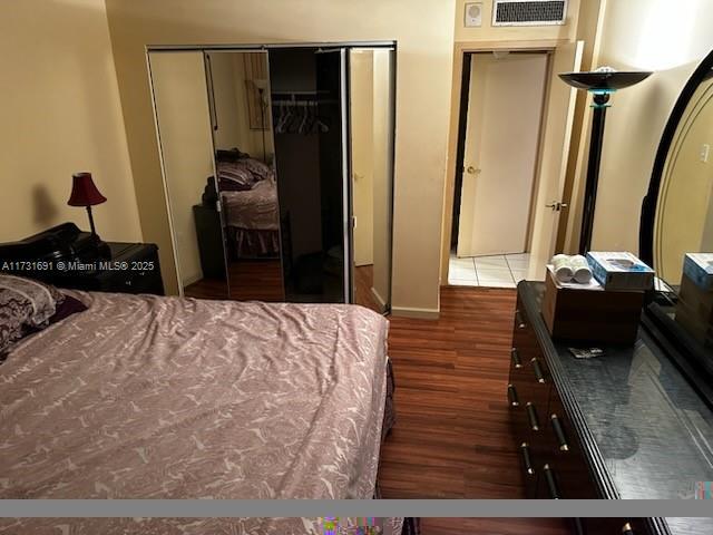 bedroom featuring dark hardwood / wood-style floors and a closet