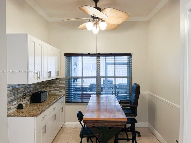 office area with ornamental molding, light tile patterned flooring, baseboards, and a ceiling fan