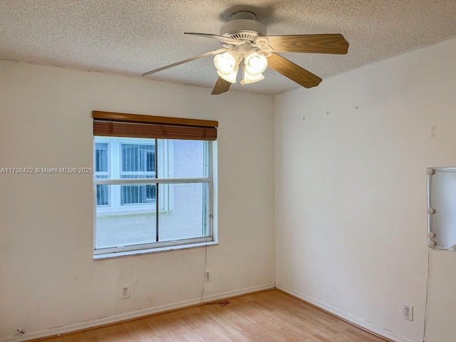 spare room featuring ceiling fan, baseboards, a textured ceiling, and wood finished floors