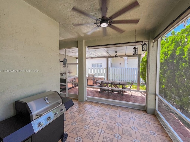 unfurnished sunroom featuring ceiling fan