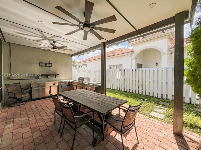 view of patio with outdoor dining area, area for grilling, a grill, fence, and ceiling fan