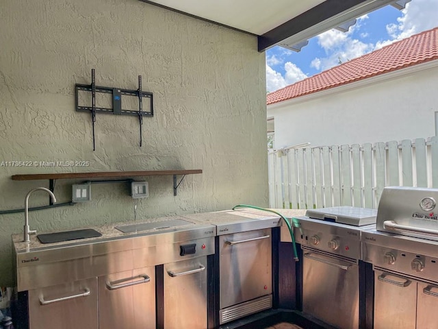 view of patio / terrace with fence, a sink, and area for grilling