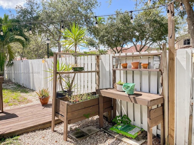 wooden terrace with a vegetable garden and fence