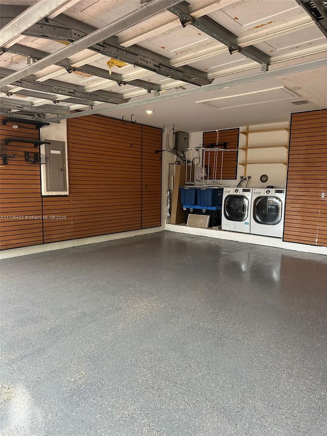 garage featuring electric panel and washing machine and clothes dryer