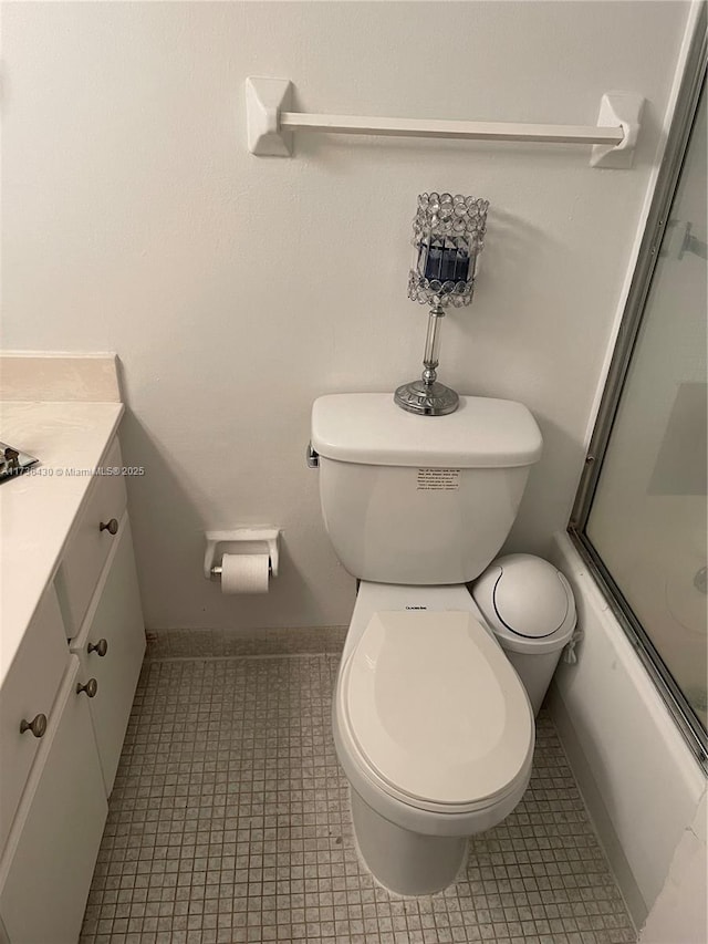 full bathroom with tile patterned flooring, vanity, shower / bath combination with glass door, and toilet