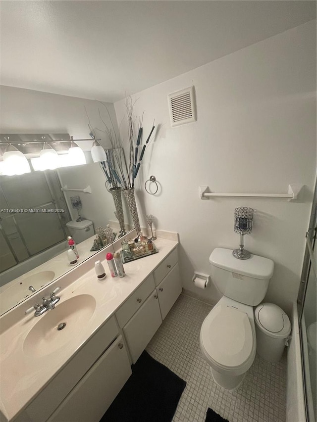 bathroom with vanity, tile patterned floors, toilet, and walk in shower