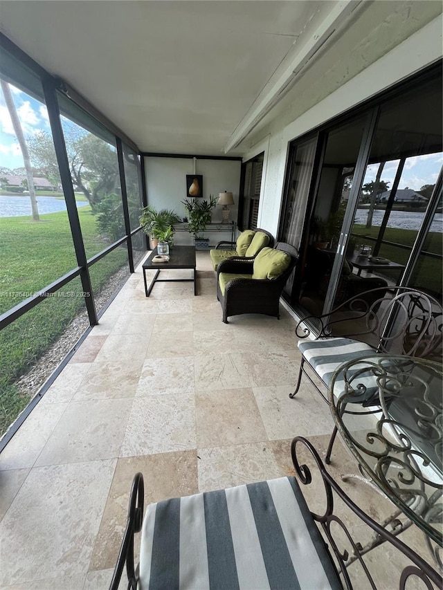 sunroom featuring a water view