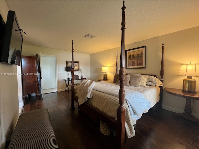 bedroom with a textured ceiling and dark hardwood / wood-style flooring