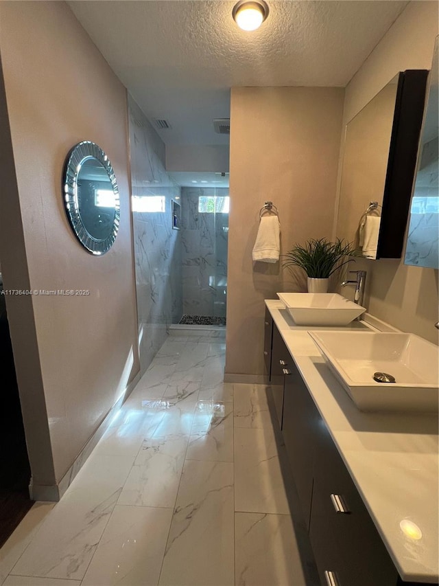 bathroom with vanity, an enclosed shower, and a textured ceiling