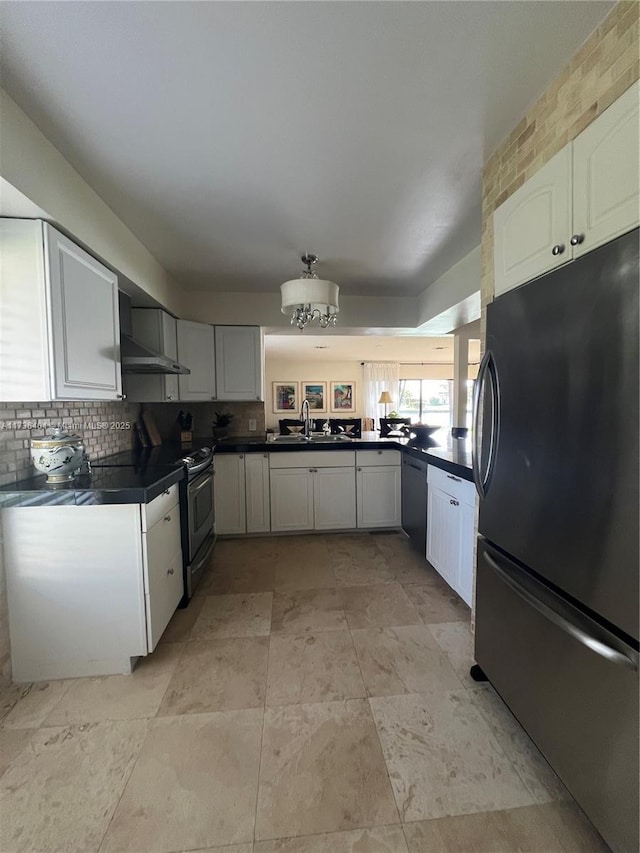 kitchen featuring wall chimney exhaust hood, sink, white cabinetry, tasteful backsplash, and stainless steel appliances