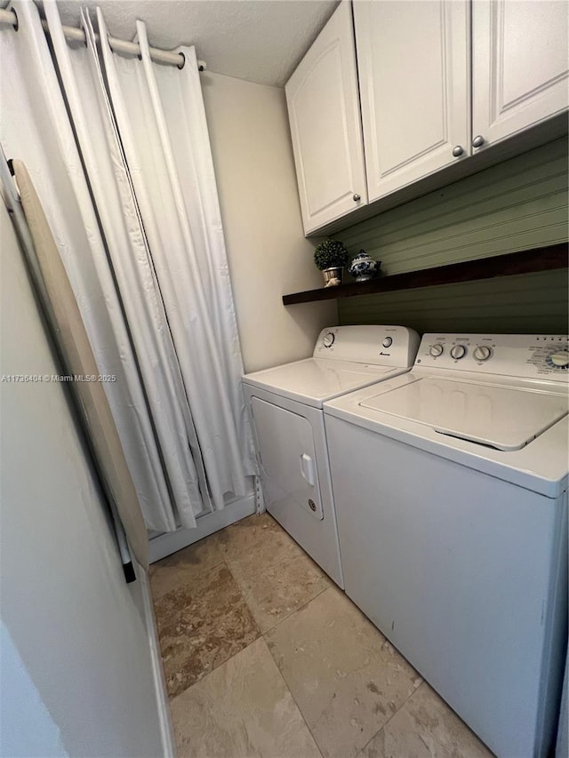 clothes washing area with cabinets and washing machine and dryer