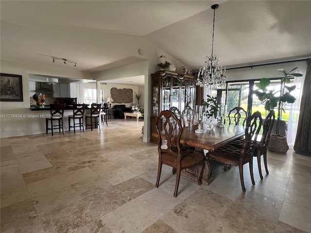 dining room with vaulted ceiling and a chandelier