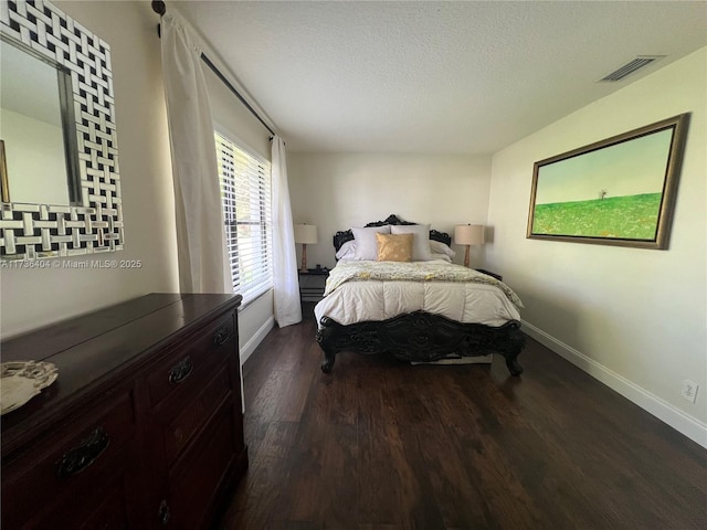 bedroom featuring dark hardwood / wood-style flooring and a textured ceiling