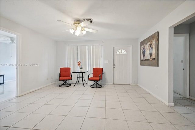 living area featuring light tile patterned floors and ceiling fan