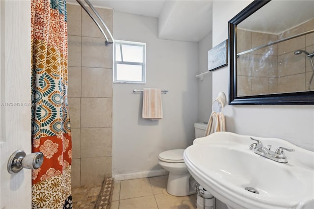 bathroom with a shower with curtain, tile patterned floors, toilet, and sink