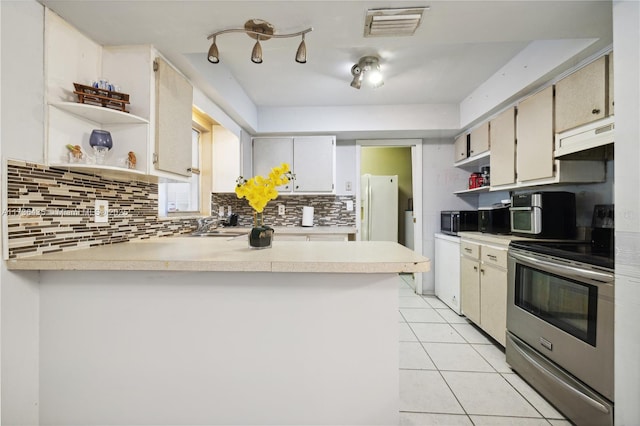 kitchen with sink, stainless steel appliances, light tile patterned flooring, decorative backsplash, and kitchen peninsula