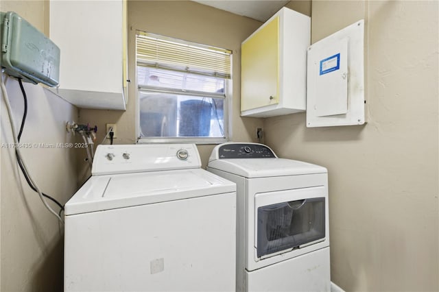 laundry area with independent washer and dryer, electric panel, and cabinets