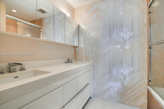 bathroom featuring vanity and bath / shower combo with glass door