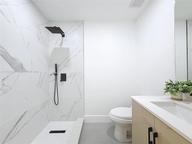 bathroom with vanity, a tile shower, and toilet