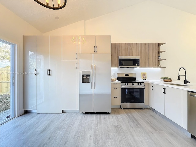 kitchen featuring appliances with stainless steel finishes, sink, high vaulted ceiling, and light hardwood / wood-style flooring