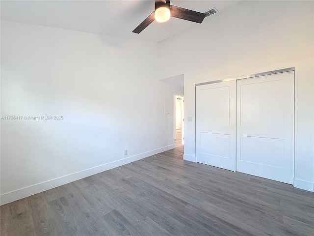 unfurnished bedroom featuring dark wood-type flooring, a closet, and ceiling fan