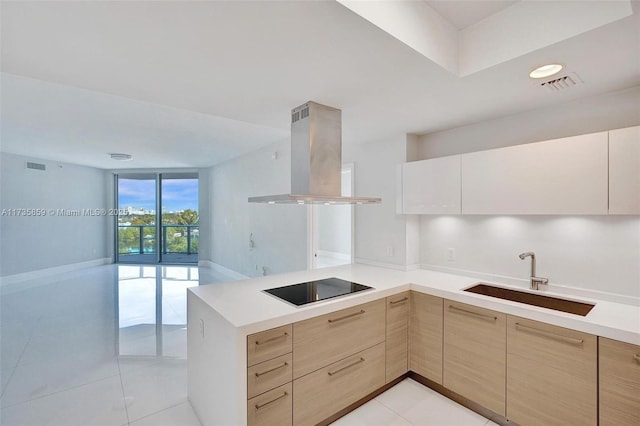 kitchen with island range hood, sink, kitchen peninsula, light brown cabinets, and black electric cooktop