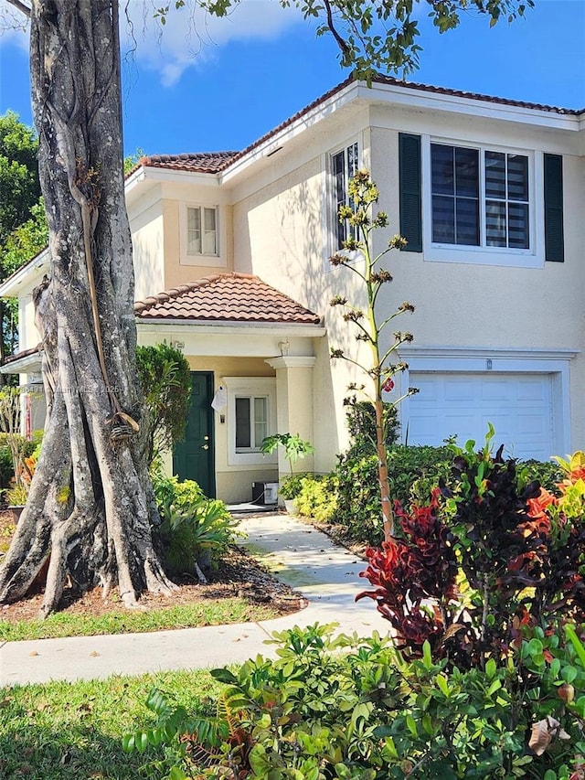 view of front of home with stucco siding, a garage, and a tiled roof