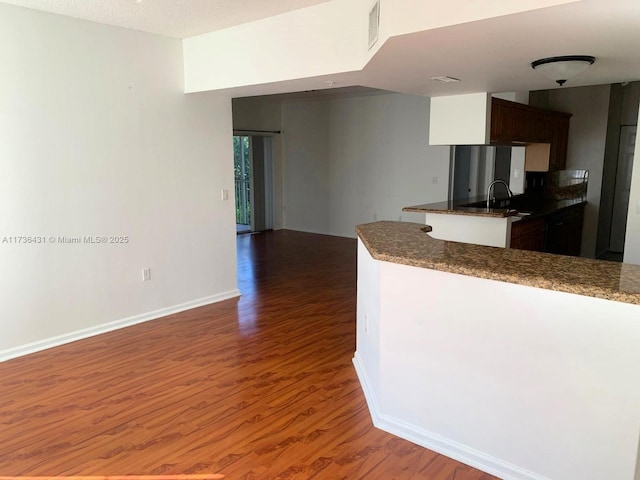 kitchen with dark brown cabinetry, sink, and dark hardwood / wood-style floors