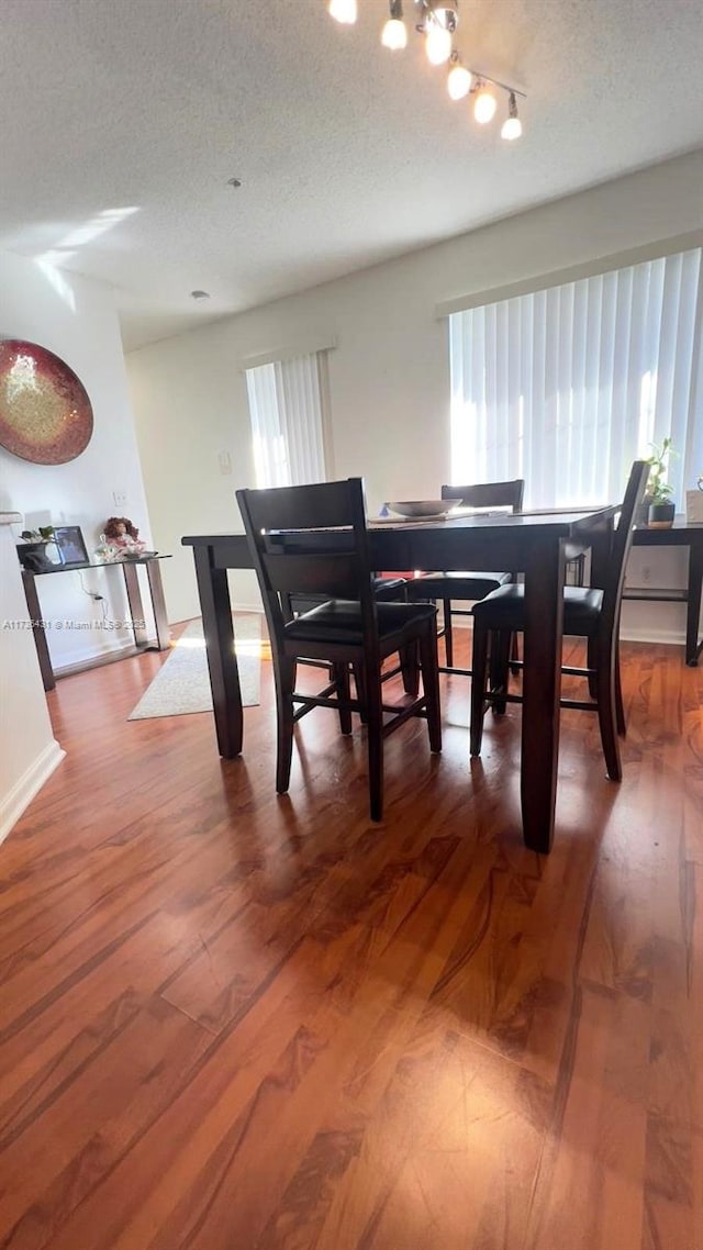 dining room with hardwood / wood-style flooring and a textured ceiling