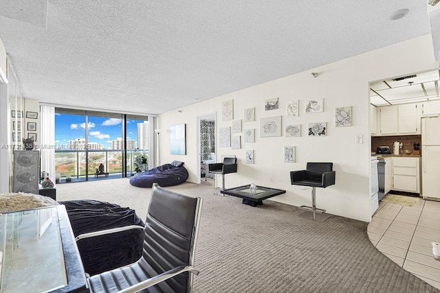 carpeted bedroom with white refrigerator, expansive windows, access to exterior, and a textured ceiling