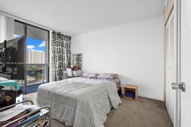 carpeted bedroom featuring access to outside, floor to ceiling windows, and a textured ceiling