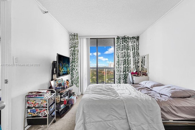 bedroom with floor to ceiling windows, access to exterior, and a textured ceiling