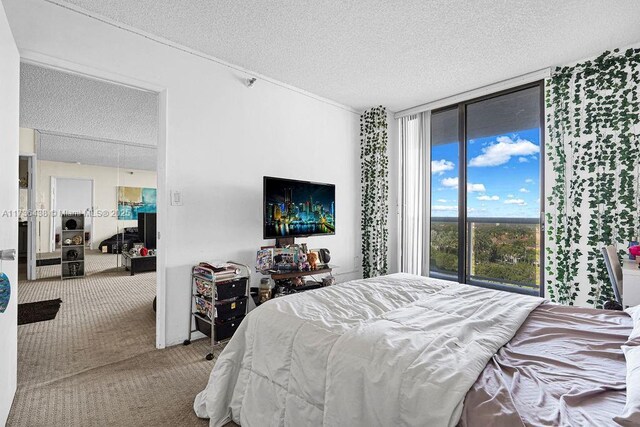 bedroom with a wall of windows, carpet floors, a textured ceiling, and access to outside