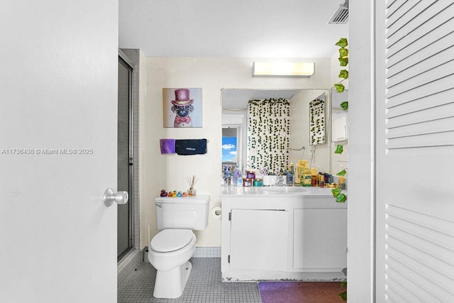 bathroom with vanity, a shower with door, tile patterned floors, and toilet