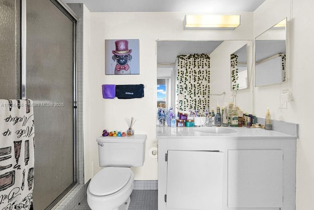 bathroom with tile patterned floors, vanity, toilet, and a shower with door