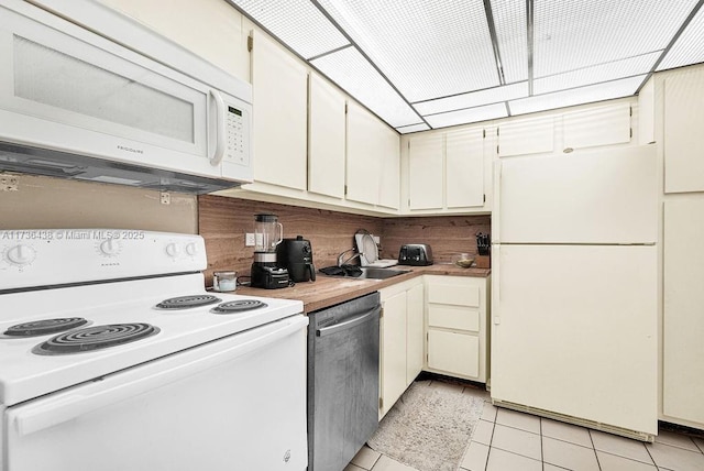 kitchen with white appliances, sink, and light tile patterned floors