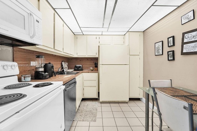 kitchen featuring white cabinets, white appliances, sink, and light tile patterned floors