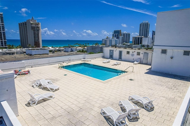 view of pool with a patio and a water view