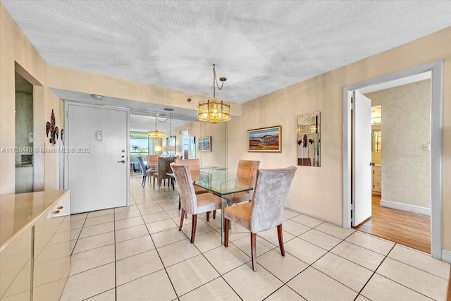 tiled dining area with an inviting chandelier and a textured ceiling