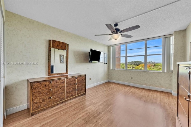 interior space with ceiling fan, light hardwood / wood-style flooring, and a textured ceiling