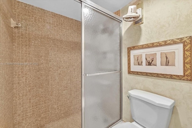 bathroom with an enclosed shower and toilet