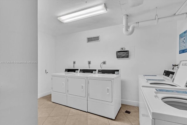 washroom featuring washing machine and dryer and light tile patterned flooring