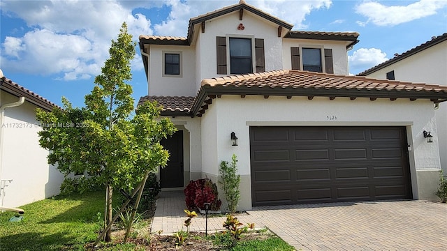 mediterranean / spanish-style home with a garage and a front yard